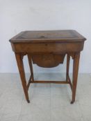 A 19th century walnut sewing table having a marquetry inlaid top with canted corners hinged to