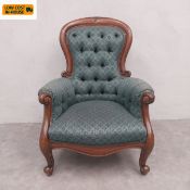 A Victorian style mahogany framed spoon back armchair with deep buttoned back and arms over a