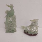 A Chinese jade figure group depicting a golden pheasant and crow among foliage raised on a wooden