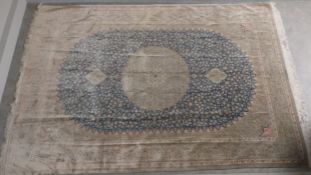 A large signed Persian silk Qum carpet with central scrolling foliate midnight blue medallion over