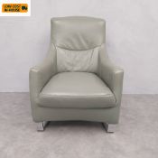 A vintage pale sage leather upholstered armchair with curved back and arms raised on flat chrome