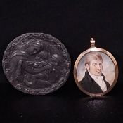 An early 19th century miniature oil portrait of a gentleman in an oval convex glazed yellow metal