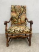 A 18th century French walnut fauteuil or open armchair having a needlework upholstered back and seat