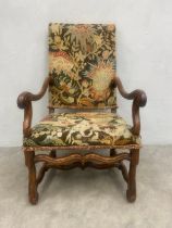 A 18th century French walnut fauteuil or open armchair having a needlework upholstered back and seat
