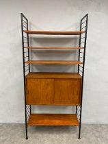 A mid-century teak and metal Ladderax modular shelving unit with four shelves and a cabinet by