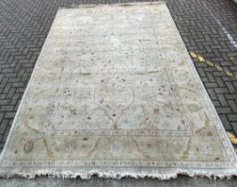 A large Turkish Oushak carpet with allover scrolling foliate decoration in muted colours over a