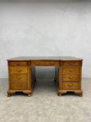 A C.1900 mahogany twin pedestal partners desk having a leather lined breakfront top over an