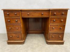 A mid 19th century mahogany pedestal desk with gilt tooled inset leather top above an arrangement of
