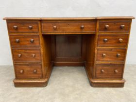 A mid 19th century mahogany pedestal desk with gilt tooled inset leather top above an arrangement of