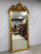 A large and impressive 19th century French giltwood floor mirror having a scrolling Rococo carved