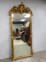 A large and impressive 19th century French giltwood floor mirror having a scrolling Rococo carved
