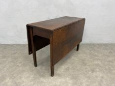 A Georgian oak D-end dining table with drop flap centre section raised on square tapering
