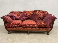 An early 20th century mahogany framed bergere sofa with ribbon and laurel leaf carving and double