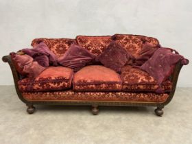 An early 20th century mahogany framed bergere sofa with ribbon and laurel leaf carving and double