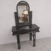 A vintage faux bamboo dressing table with an ebonised finish having a shaped swing mirror over three