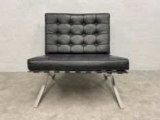 A vintage black leather upholstered 'Barcelona' chair on shaped chrome x-frame supports after the
