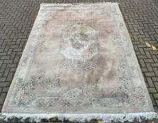 A Chinese woollen carpet with allover bird and scrolling foliate decoration on a blush field