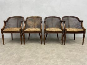 A set of four early 20th century mahogany Bergere tub armchairs each having a shaped cane back, seat