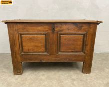 A 19th century oak coffer or blanket chest with a plank top enclosing candle box over a panelled