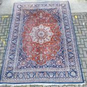A large hand knotted Persian Kashan carpet with central flowerhead medallion and polychrome