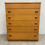 A mid-century teak dressing chest of drawers with hinged top enclosing a fitted interior with
