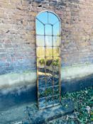 A contemporary pier or wall mirror in arched bronzed metal window pane frame. 190x50cm.