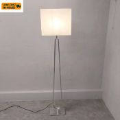 A contemporary Ikea Klabb floor lamp with square shade and brushed steel stem raised on a square