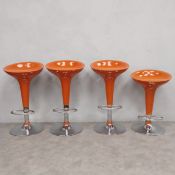 A set of four contemporary retro styled bar or counter stools each with a splayed circular orange