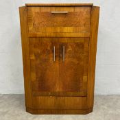 A 1930s Art Deco burr walnut cocktail cabinet with hinged top and fall front enclosing a fitted