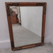 A vintage Continental wall mirror with carved gilt and ebonised scrolling frame. H.96 W.75.5cm