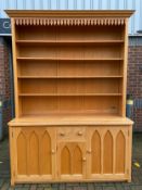 A 19th century Gothic style light oak two section dresser or open bookcase with shelves above arched