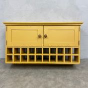 A vintage painted wall hanging cabinet with a pair of panelled cupboard doors over an open wine rack