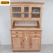 A C.1900 pitch pine kitchen dresser in two parts having a superstructure with three glazed cabinet