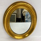A gilt framed wall mirror with oval plate. 40x47cm.