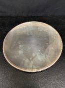 A silver card tray or shallow dish with ribbed edge, monogrammed and marked sterling to the