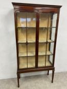 An Edwardian mahogany display cabinet with egg and dart moulded cornice over a pair of astragal