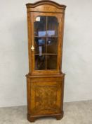 A Georgian style walnut corner cabinet with shaped pediment over the astragal glazed door