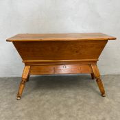 A 19th century pine dough box table with plank top over the tapered trough raised on turned