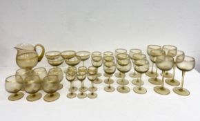 A suite of coloured glasses to include four sets of hock glasses, champagne coups, brandy glasses