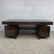 A contemporary Winston desk having a floating rectangular top with four frieze drawers over a pair