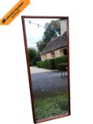 A mid-century teak framed wall dressing mirror. 137x56cm.