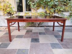 A contemporary Chinese stained and polished teak to match Lot 64, extending dining table with two
