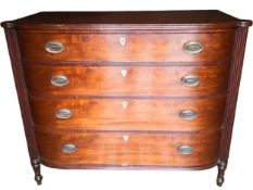 A Regency mahogany bow fronted chest of four long drawers flanked by reeded pilasters on turned