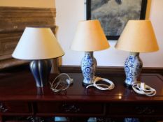 A pair of Chinese blue and white baluster shaped table lamps and a contemporary similar with shades.