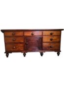 A 19th century mahogany Lancashire type dresser fitted with drawers and a central cupboard raised on