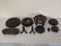 A collection of eight Chinese carved hardwood stands. Dia.26cm.