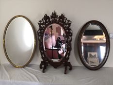 A C.1900 gilt framed mirror with oval bevelled plate, a vintage oak example and a Chinese carved