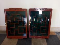 Two Chinese carved and lacquered teak wall hanging display cabinets fitted with shelves. H.67 W.46