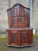 A Dutch 18th century walnut two section cabinet with arched carved pediment above panel doors fitted