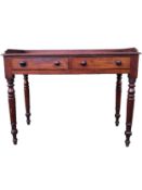 A mid 19th century mahogany writing table with gallery back above frieze drawers on turned